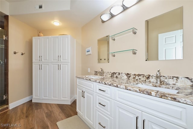 bathroom featuring vanity, an enclosed shower, and wood-type flooring