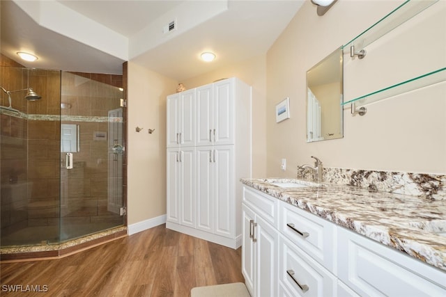 bathroom with vanity, hardwood / wood-style floors, and a shower with shower door