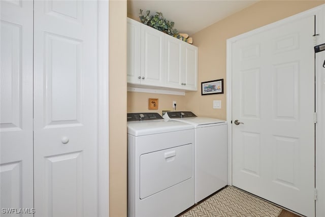 laundry room featuring washing machine and dryer and cabinets