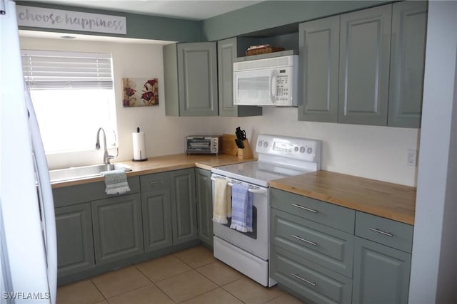 kitchen featuring a sink, white appliances, butcher block countertops, and gray cabinets