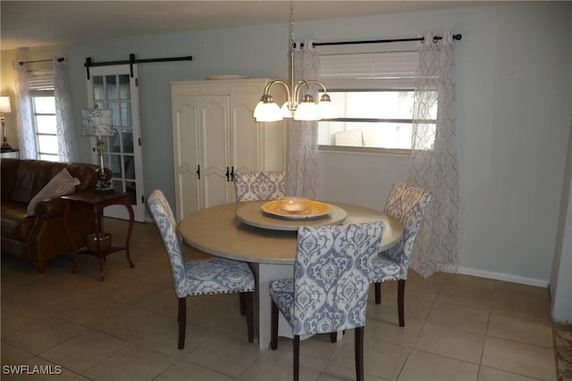 dining space with light tile patterned floors, a barn door, and baseboards