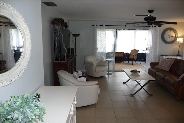 living area with visible vents, ceiling fan, and light tile patterned floors