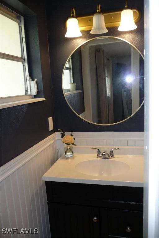 bathroom with a wainscoted wall and vanity