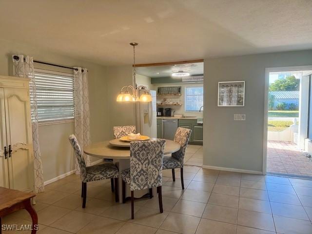 dining space with baseboards, plenty of natural light, light tile patterned flooring, and an inviting chandelier