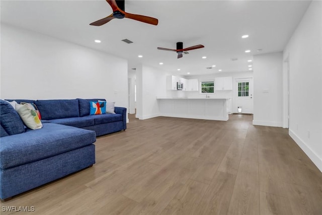 living room featuring ceiling fan and light wood-type flooring