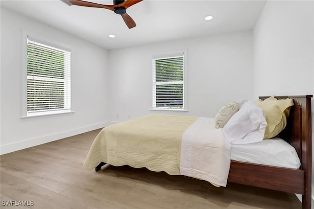 bedroom featuring multiple windows, ceiling fan, and light hardwood / wood-style flooring