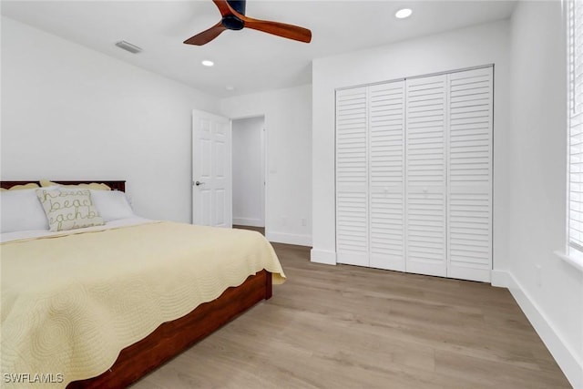 bedroom featuring ceiling fan, light wood-type flooring, and a closet