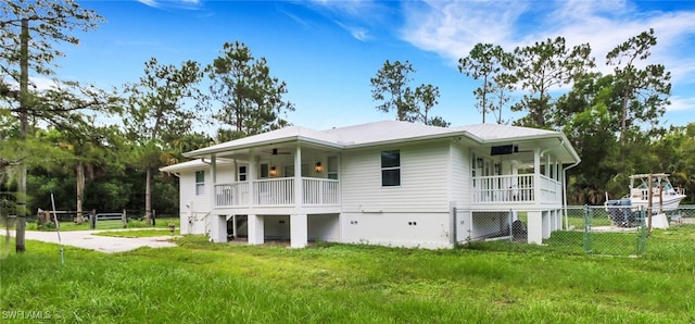 back of property with a porch, a yard, and ceiling fan