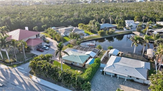 birds eye view of property with a view of trees, a residential view, and a water view