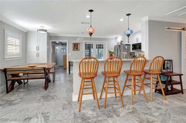 kitchen with a wealth of natural light, ornamental molding, and appliances with stainless steel finishes