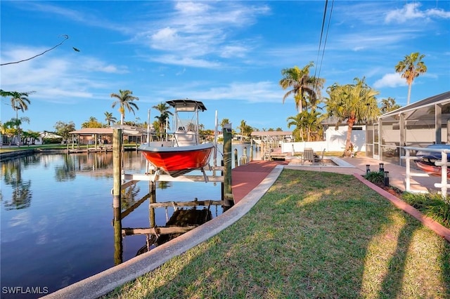 dock area with boat lift, a lawn, and a water view