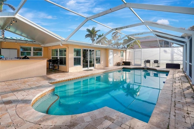 pool with glass enclosure and a patio