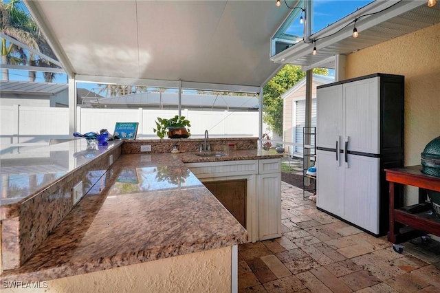 view of patio with fence and a sink