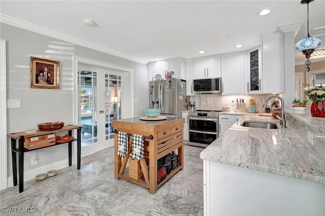 kitchen featuring crown molding, appliances with stainless steel finishes, light stone counters, a sink, and french doors
