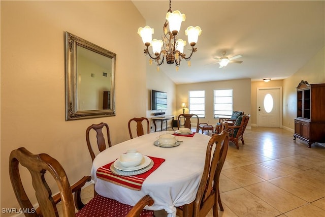 dining space featuring vaulted ceiling, ceiling fan with notable chandelier, and light tile patterned floors