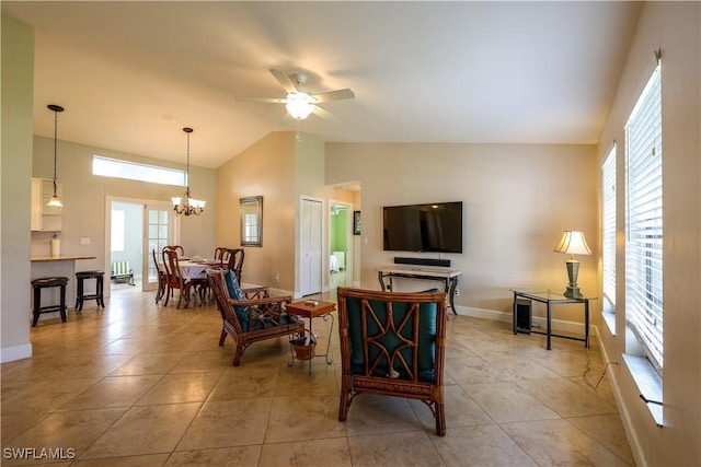 living room with light tile patterned flooring, ceiling fan with notable chandelier, and high vaulted ceiling