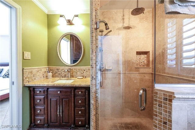 bathroom featuring ornamental molding, a shower with door, and vanity