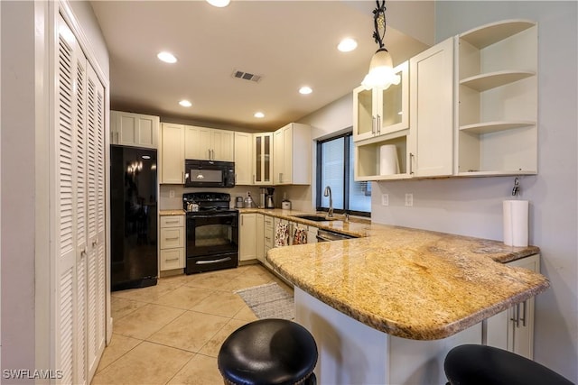 kitchen featuring hanging light fixtures, black appliances, kitchen peninsula, and a breakfast bar