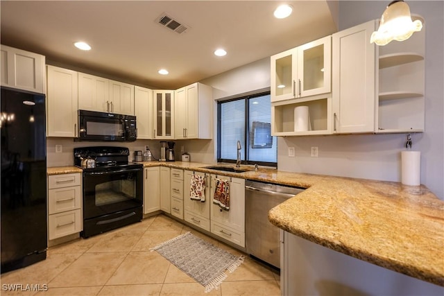 kitchen featuring pendant lighting, white cabinets, and black appliances