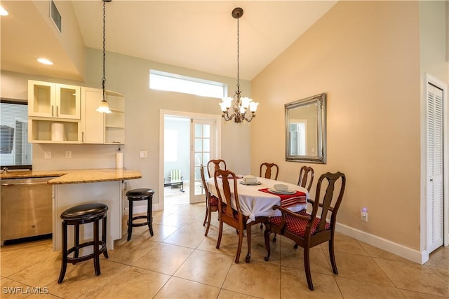 tiled dining area with high vaulted ceiling and a chandelier