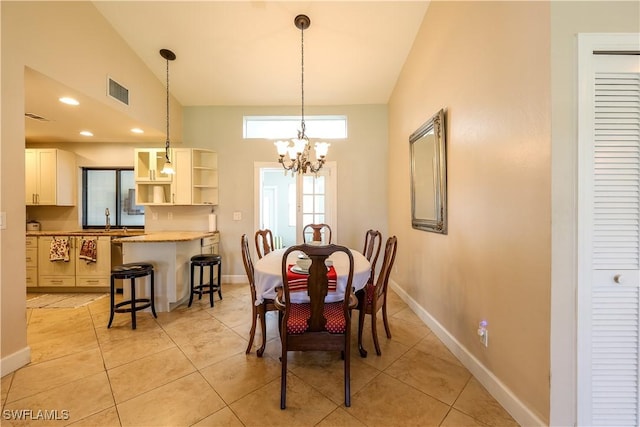 tiled dining area featuring high vaulted ceiling, a chandelier, and sink