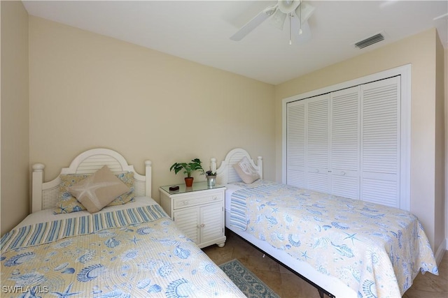 bedroom featuring dark tile patterned flooring, ceiling fan, and a closet