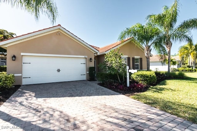 ranch-style home featuring a garage and a front lawn