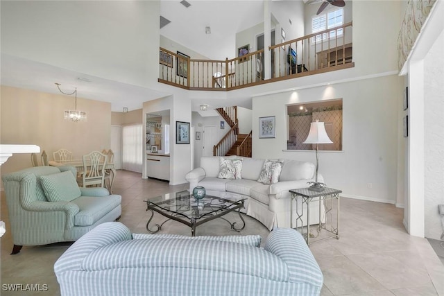 tiled living area featuring stairs, a chandelier, visible vents, and baseboards