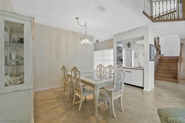 dining room with light tile patterned floors, a chandelier, visible vents, baseboards, and stairs