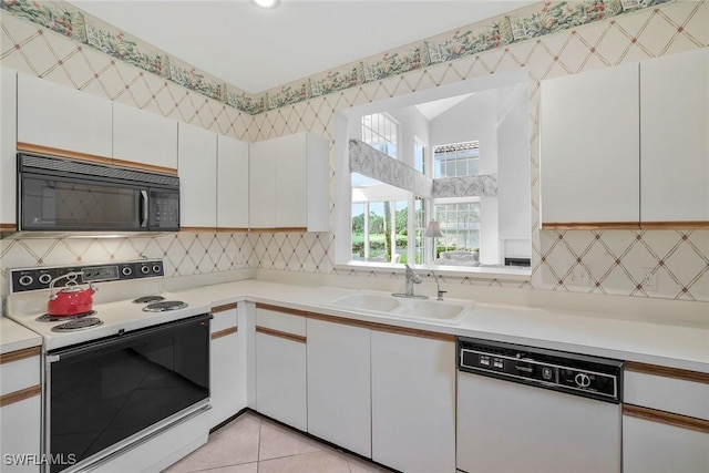 kitchen featuring white cabinets, dishwasher, black microwave, a sink, and range with electric stovetop