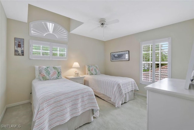 bedroom featuring baseboards, a ceiling fan, and light colored carpet