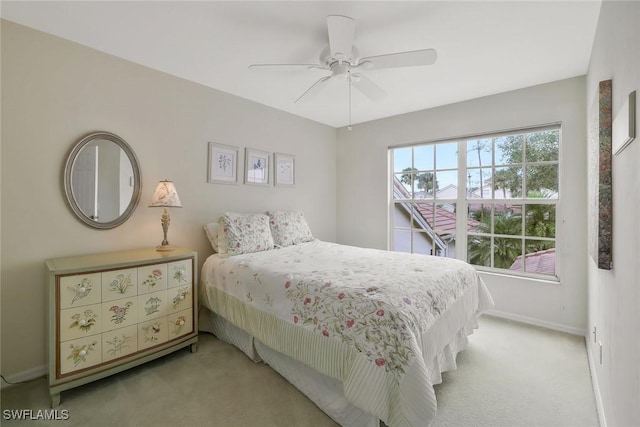 bedroom with a ceiling fan, light carpet, and baseboards