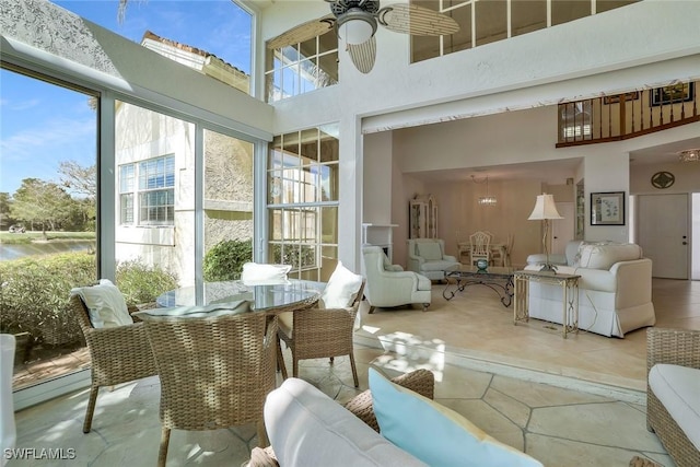 sunroom / solarium featuring a ceiling fan