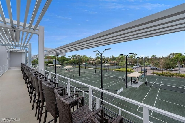 view of home's community with a tennis court, fence, and a pergola