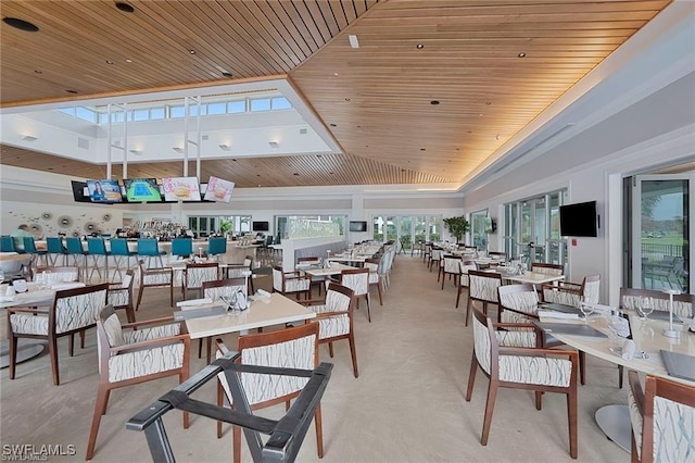 carpeted dining space featuring high vaulted ceiling and wooden ceiling