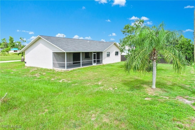 back of house with a yard and a sunroom