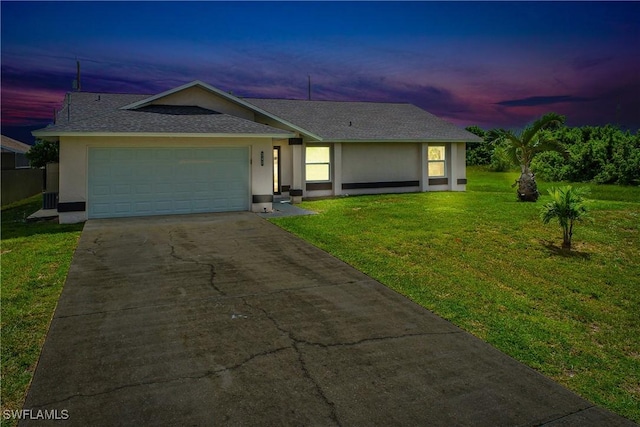 ranch-style home with a garage and a yard