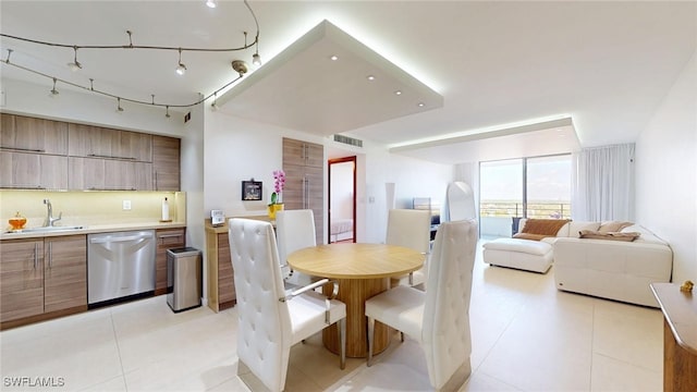 dining space featuring sink, light tile patterned floors, and track lighting