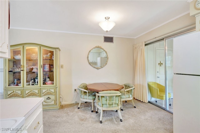 carpeted dining room featuring crown molding