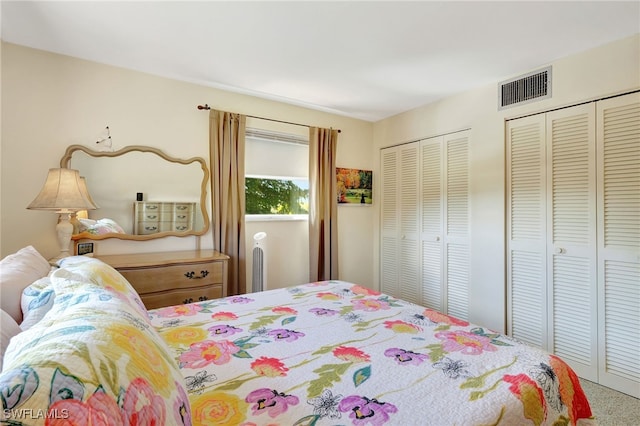 bedroom featuring multiple closets and carpet