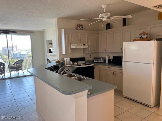 kitchen with range with electric stovetop, sink, white fridge, ceiling fan, and kitchen peninsula