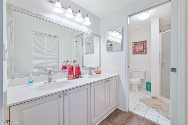 bathroom featuring walk in shower, vanity, tile patterned floors, and toilet