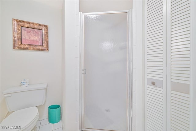 bathroom featuring an enclosed shower, tile patterned floors, and toilet