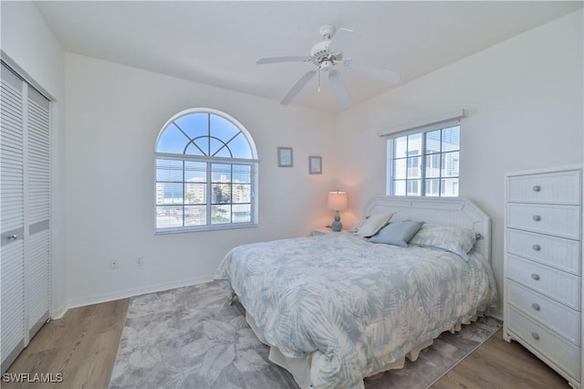 bedroom with a closet, ceiling fan, and light hardwood / wood-style flooring