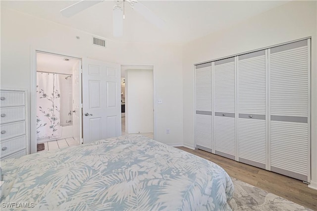 bedroom featuring ceiling fan, connected bathroom, light hardwood / wood-style floors, and a closet