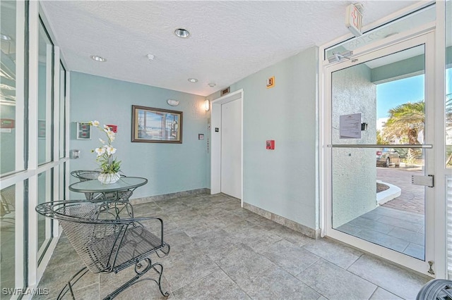 interior space with elevator and a textured ceiling