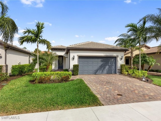 mediterranean / spanish home featuring a garage and a front lawn