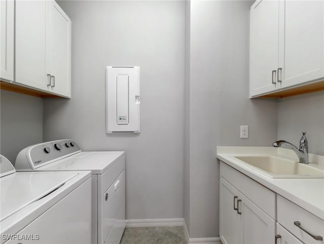 washroom with cabinets, washing machine and dryer, and sink