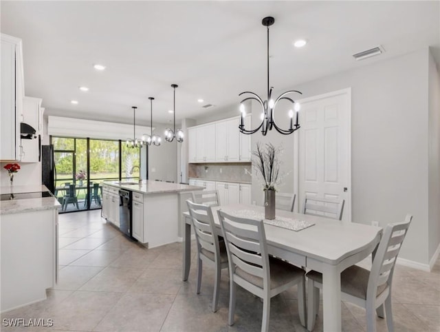 dining space with light tile patterned floors and an inviting chandelier