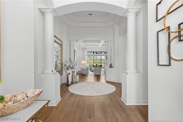 foyer with ornamental molding, decorative columns, baseboards, and wood finished floors